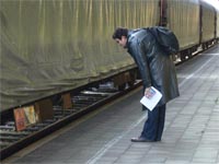 Passant im Gronauer Bahnhof vor Transportwaggons mit Uranhexafluorid